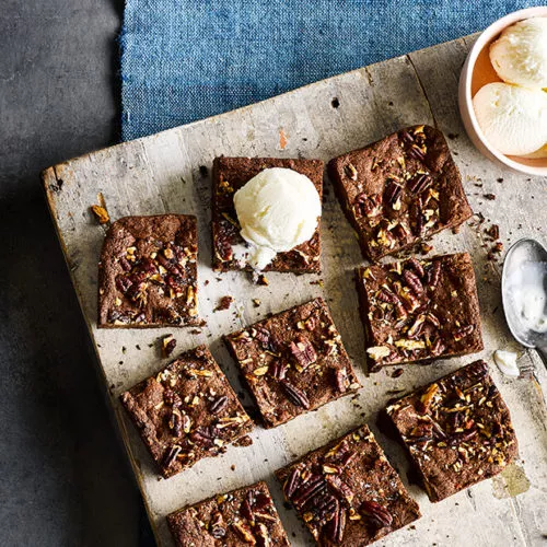 hazelnut brownies cut into squares with vanilla ice cream