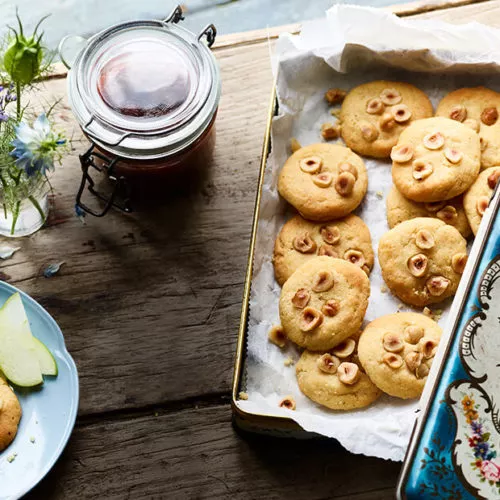 Hazelnut shortbread cookies on a tray with jam