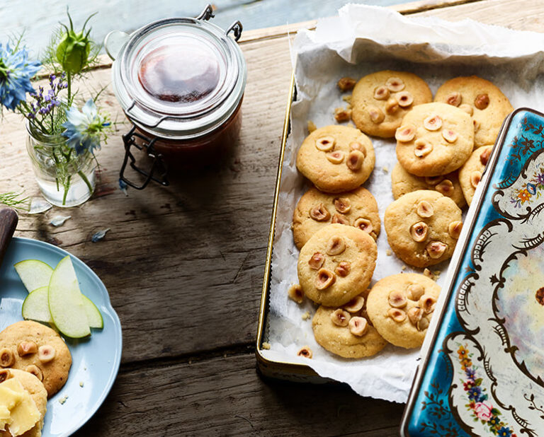 Hazelnut shortbread cookies on a tray with jam